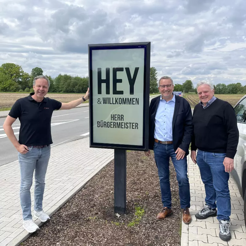 Bürgermeister Andreas Kaiser, Michael Gordalla und Franz Gordalla vor einer Digital -Signage-Outdoor Stele der Heyden-Securit GmbH